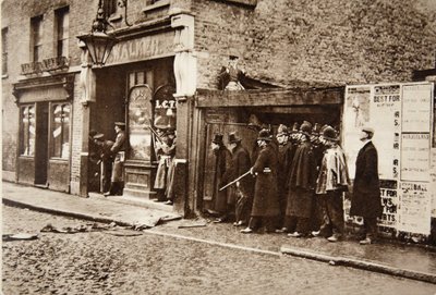 Um die Ecken schauend, setzte er sich mit den Scots Guards dem zufälligen Feuer der belagerten Einbrecher aus: Mr. Winston Churchill mit Zylinder im East End von London, während des Sidney Street Dramas von English Photographer